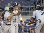 Seattle Mariners' Raul Ibanez, left, is congratulated by Michael Morse, right, after hitting a grand slam off New York Yankees starting pitcher Phil Hughes during the first inning of a baseball game at Yankee Stadium in New York, Wednesday, May 15, 2013.