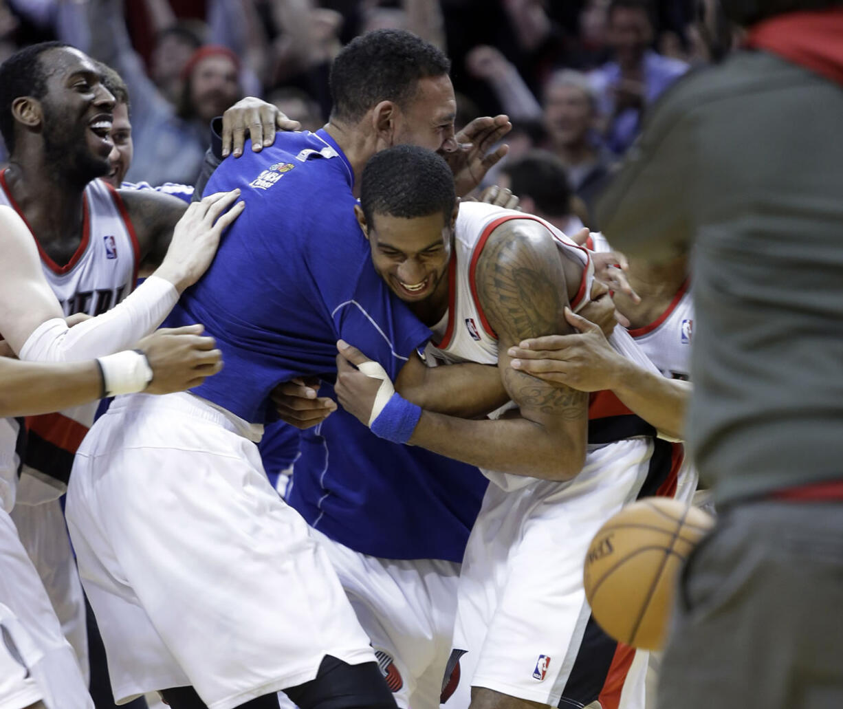 Portland Trail Blazers forward LaMarcus Aldridge, right, is mobbed by teammates after sinking a shot at the buzzer against the Dallas Mavericks on Tuesday.