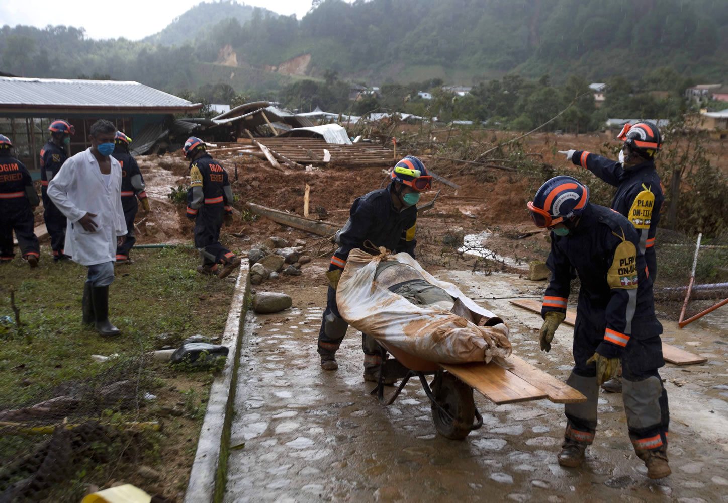 EDS NOTE: GRAPHIC CONTENT - Soldiers remove a body recovered from the site of a landslide in La Pintada, Mexico, Saturday, Sept. 21, 2013. The village was the scene of the single greatest tragedy in destruction wreaked by the twin storms, Manuel and Ingrid, which simultaneously pounded both of Mexico's coasts. Using picks and shovels, soldiers and farmers removed dirt and rock from atop the cement or corrugated-metal roofs of houses looking for bodies in this town north of Acapulco, where 68 people were reported missing following Monday's slide.