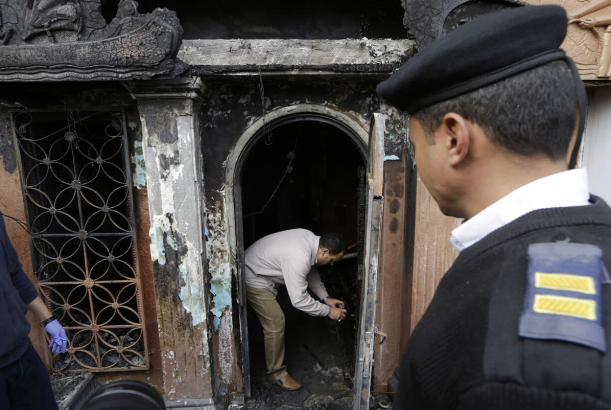 An Egyptian forensic member checks the gate of the nightclub which was attacked in Cairo, Egypt, on Friday. More than a dozen were killed and wounded, Egypt&#039;s state-run news agency reported. MENA quoted an unnamed security official as saying three men on a motorcycle threw Molotov cocktails into the club in the Agouza district and then fled.