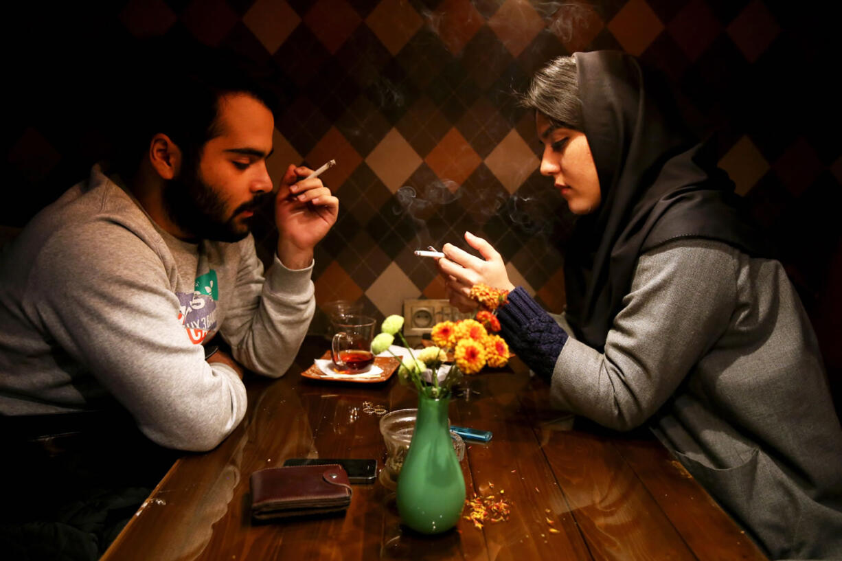 An Iranian man and a woman enjoy their time at a cafe in downtown Tehran, Iran, on Tuesday.