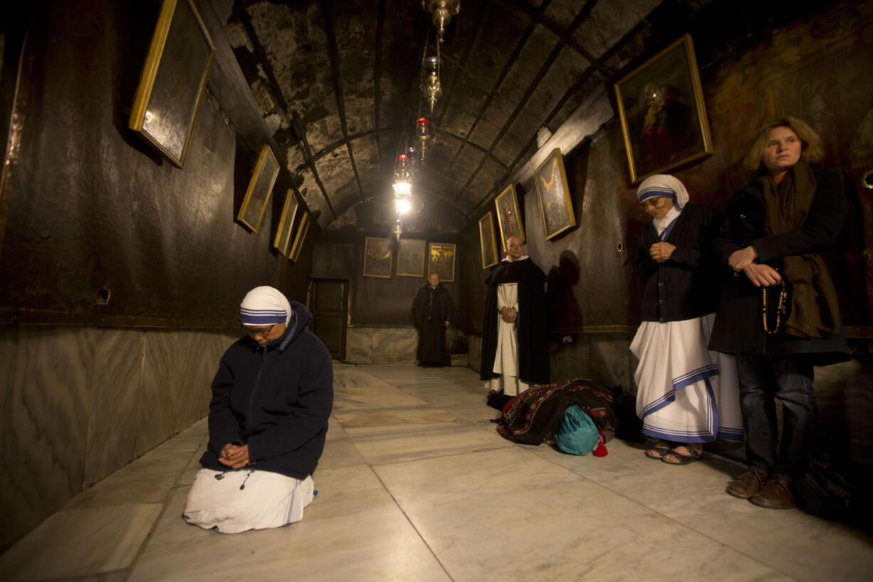 A nun prays inside the Grotto at the Church of the Nativity, traditionally believed by Christians to be the birthplace of Jesus Christ, in the West Bank city of Bethlehem on Christmas Eve.