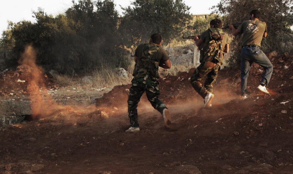 Free Syrian Army soldiers aim their weapons Friday in Idlib province, northern Syria.