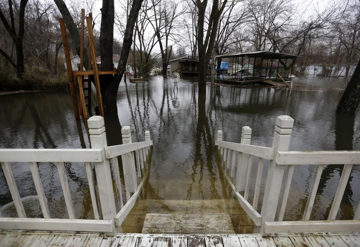 Floodwaters approach the deck of a home in Branson, Mo., caught in the rising waters of Lake Taneycomo.