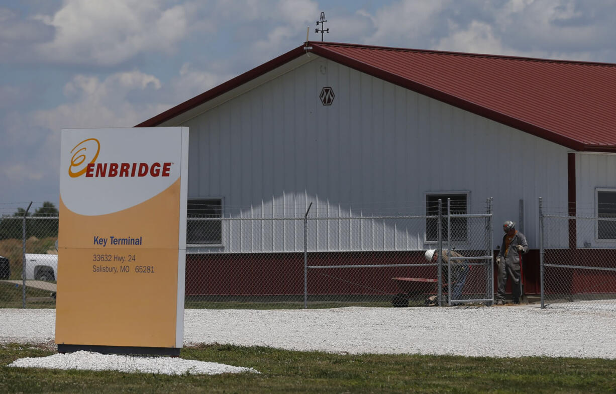 Workers move gravel around a building at the Enbridge Key Terminal near Salisbury, Mo., on Tuesday.