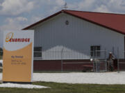 Workers move gravel around a building at the Enbridge Key Terminal near Salisbury, Mo., on Tuesday.