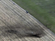 A dark scar marks a farm field at the site of a crash of a Navy aircraft Monday near Harrington, in Eastern Washington. A U.S.