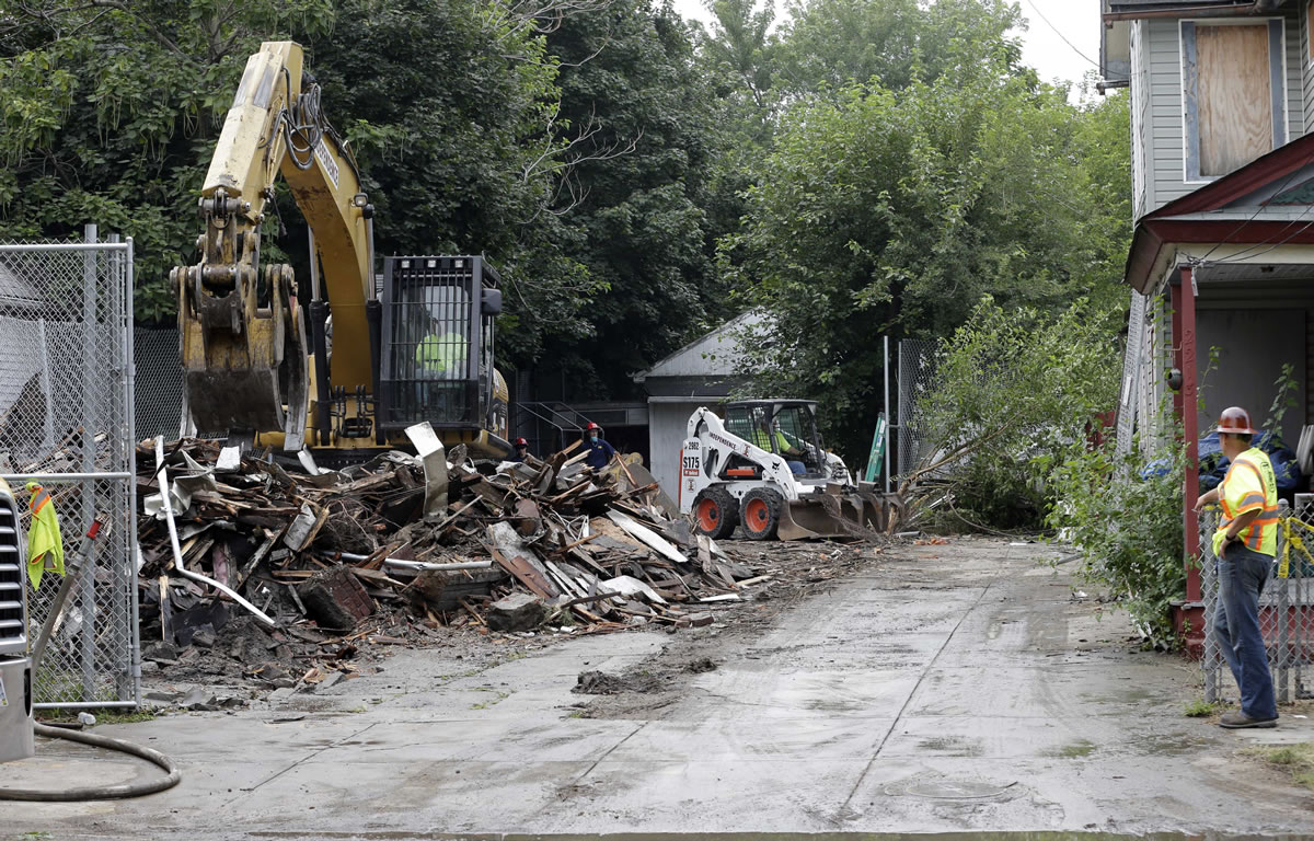 Workers demolish the house where three women were held captive and raped for more than a decade, Wednesday in Cleveland.