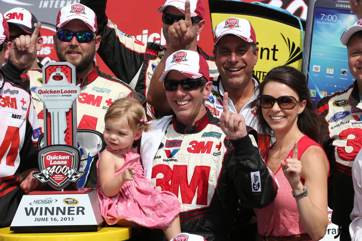 Sprint Cup Series driver Greg Biffle holds his daughter Emma Elizabeth and stands next to his wife Nicole Lunders after winning the NASCAR Quicken Loans 400 at Michigan International Speedway on Sunday.