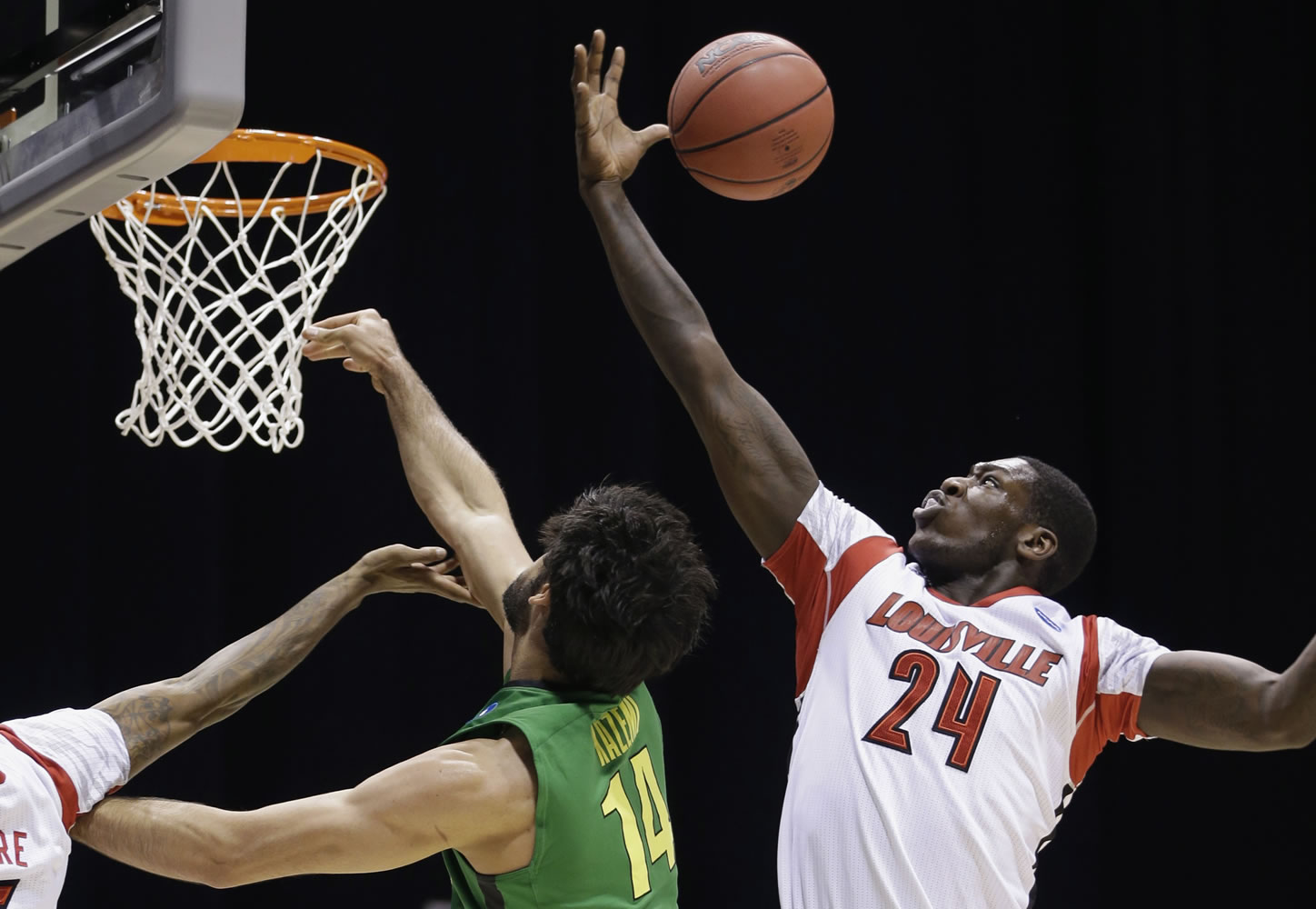 Louisville forward Montrezl Harrell (24) reaches for a rebound against Oregon forward Arsalan Kazemi (14) during the first half Friday.