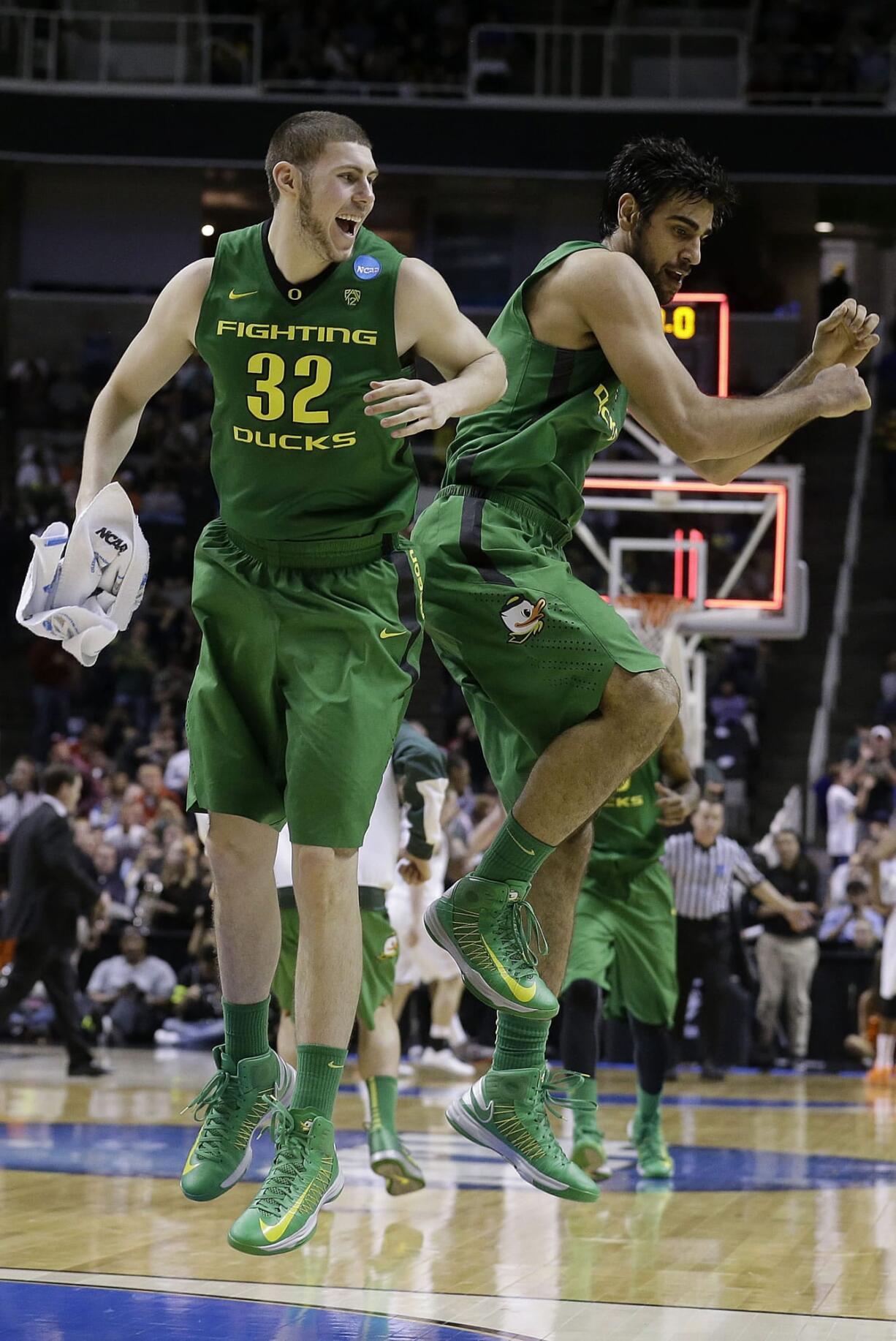 Oregon forward Ben Carter (32) and forward Arsalan Kazemi celebrate at the end of the first half Thursday.