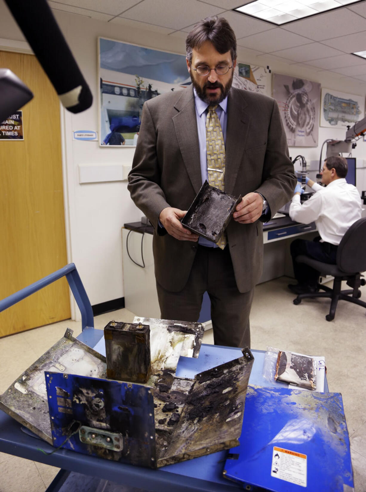 The National Transportation Safety Board's Joseph Kolly, holds a damaged battery cell case from the Japan Airlines Boeing 787 that caught fire at Logan International Airport in Boston on Jan.