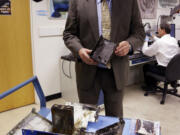 The National Transportation Safety Board's Joseph Kolly, holds a damaged battery cell case from the Japan Airlines Boeing 787 that caught fire at Logan International Airport in Boston on Jan.