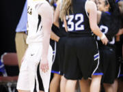 The Clark College women's basketball team celebrates in the background as Walla Walla's Michelle Seitz leaves the court at the Toyota Center in Kennewick.