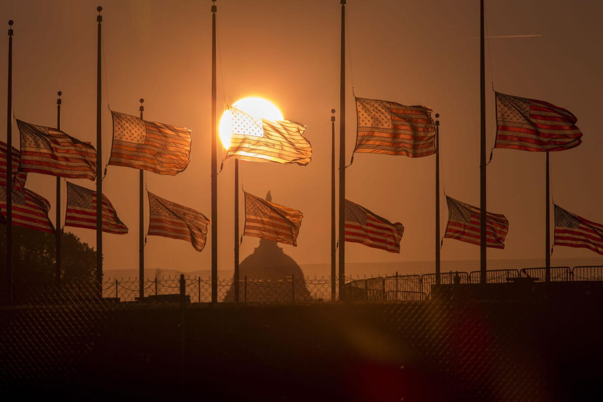 The American flags surrounding the Washington Monument fly at half-staff as ordered by President Barack Obama following the deadly shooting Monday at the Washington Navy Yard on Tuesday morning in Washington.