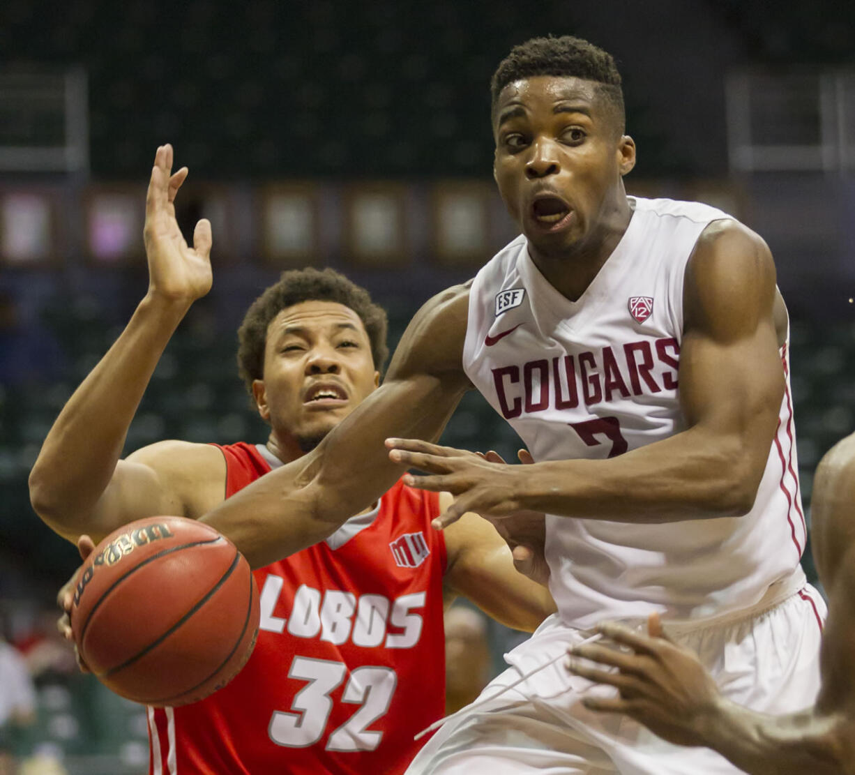 Washington State guard Ike Iroegbu (2) passes off the basketball while being defended by New Mexico forward Tim Williams (32) in the second half of an NCAA college basketball game at the Diamond Head Classic, Friday, Dec. 25, 2015, in Honolulu. Washington State won 82-59.