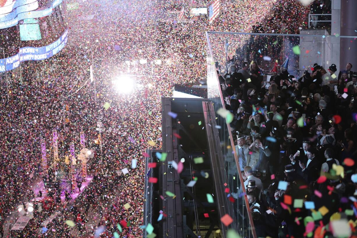 Revelers celebrate as confetti flies over New York&#039;s Times Square after the clock strikes midnight during the New Year&#039;s Eve celebration as seen from the New York Marriott Marquis hotel, Friday, Jan. 1, 2016.