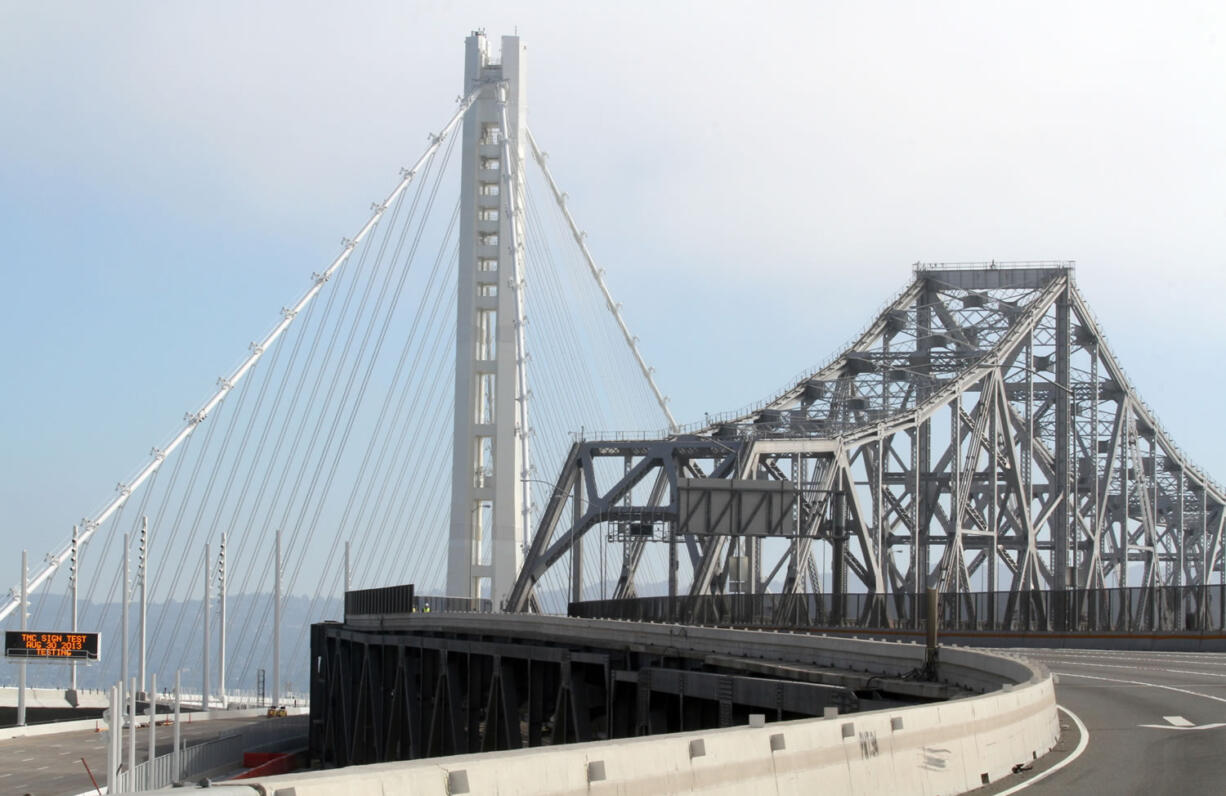 The old, right, and the new Bay bridges come together Friday during the bridge closure in Oakland, Calif.