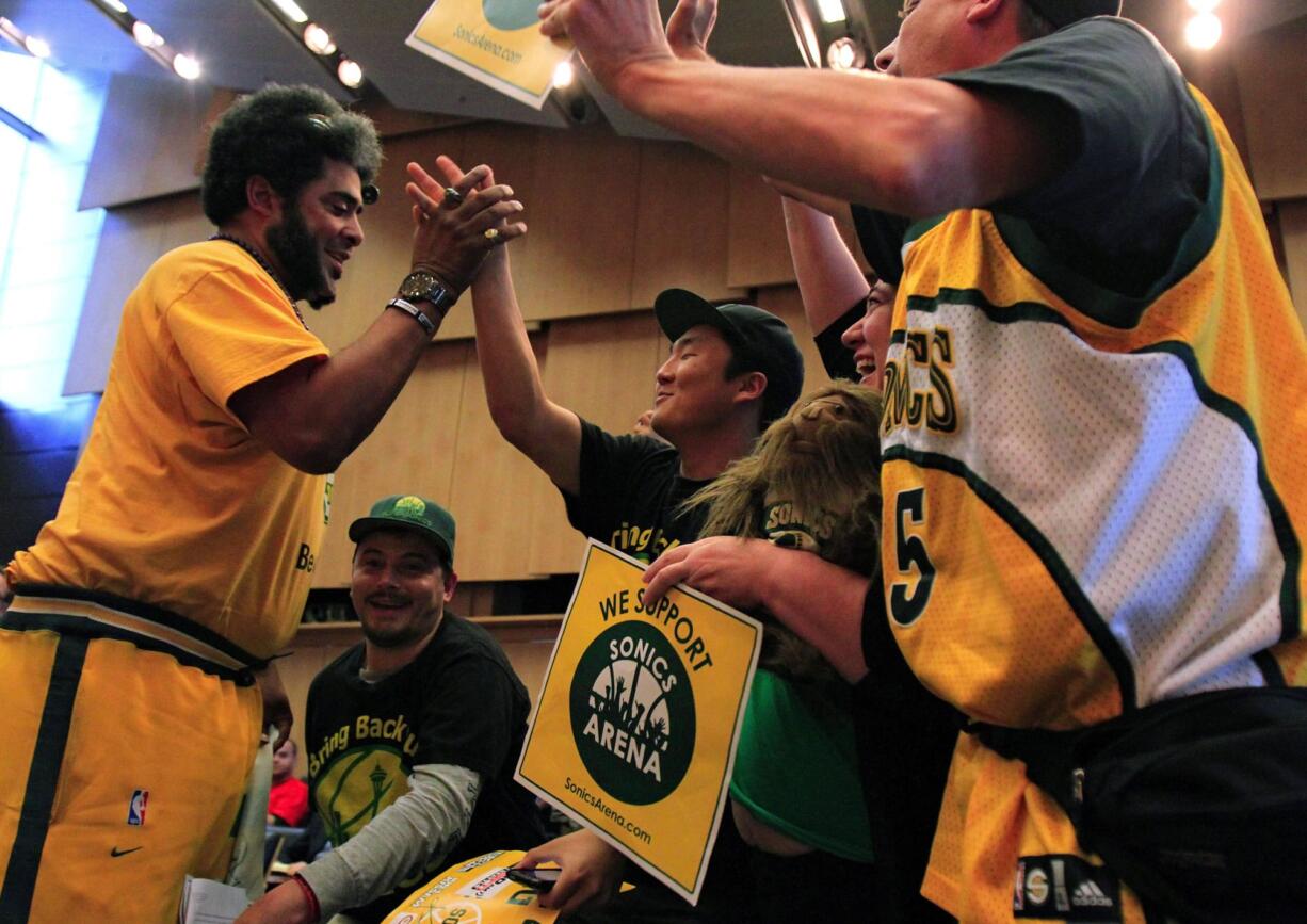 Supporters of the new arena plan, from left, Kris Brannon, Jason Billingsley, Joseph Chong, Dawn Welch and Kenneth Knutsen, celebrate after the Seattle City Council voted to accept Chris Hansen's plan to build a new $490 million arena with $200 million in public bonds on Monday in Seattle.