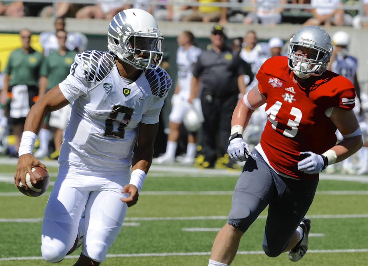 Oregon's quarterback Marcus Mariotta (8) runs against Nicholls State Ryan Bruno (43) during the first half Saturday.