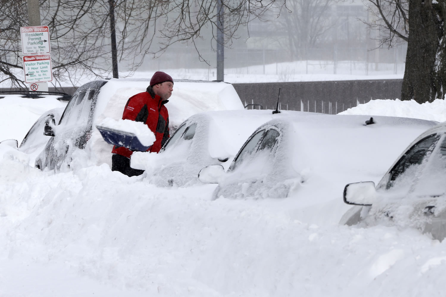 A man shovels snow off his car on M street in the South Boston neighborhood of Boston Saturday, Feb. 9, 2013 in Boston. Boston was blanketed in up to 2 feet of snow, falling short of the city's record of 27.6 inches set in 2003. In some communities just outside the city, totals were higher, including 30 inches in Quincy and Framingham. (AP Photo/Gene J.