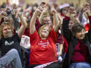 Coal export opponents, from left, Wayne Spitzer, Ginger Hughes and April Beasley show their disapproval of a pro-coal speaker testifying on the proposed Cherry Point coal export terminal Dec.