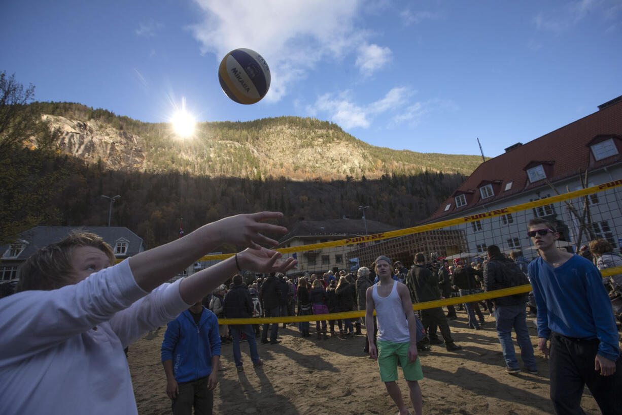 Youths play games Wednesday after the official opening of giant sun mirrors in the town of Rjukan, Norway.