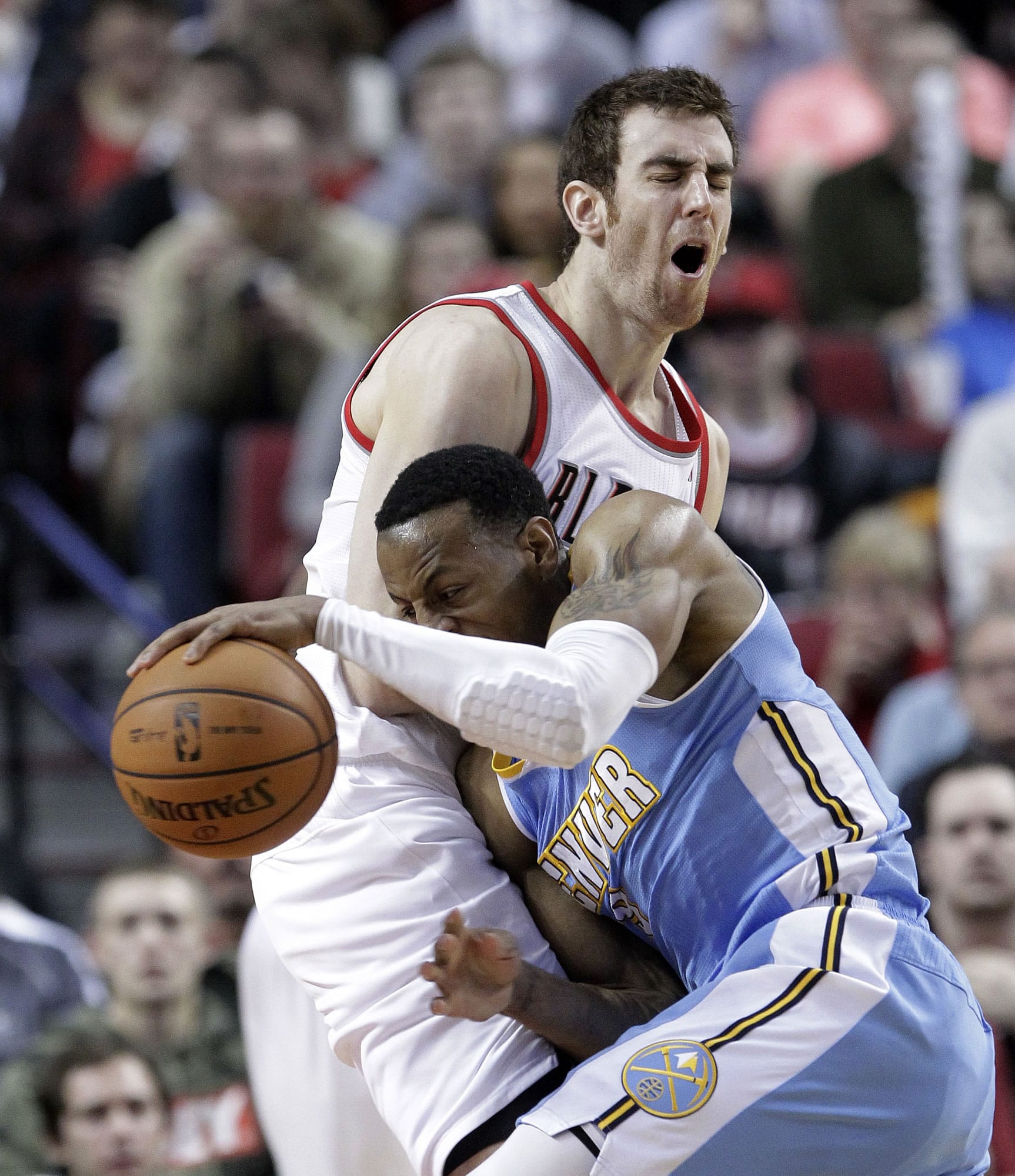 Don Ryan/The Associated Press
Denver Nuggets guard Andre Iguodala, right, collides with Portland Trail Blazers forward Victor Claver during the second half Wednesday.  Iguodala scored 29 points as Denver beat Portland 111-109.