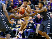 Washington's Dejounte Murray, center, is pressured by Oakland's Kay Felder, left, and Sherron Dorsey-Walker during an NCAA college basketball game Saturday, Dec. 19, 2015, in Seattle. Oakland won 97-83.