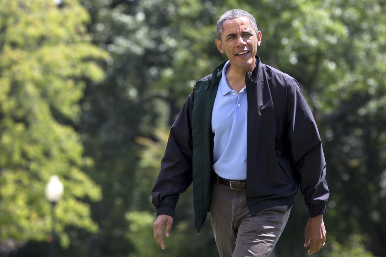 President Barack Obama walk across the South Lawn of the White House after returning from Camp David on his 52nd birthday, in Washington on Sunday.