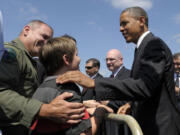 President Barack Obama talks to Vancouver residents Thomas Bieniewicz, 10, and his father, Col. Mike Bieniewicz, left, after arriving at the Oregon Air National Guard Base in Portland on Tuesday.