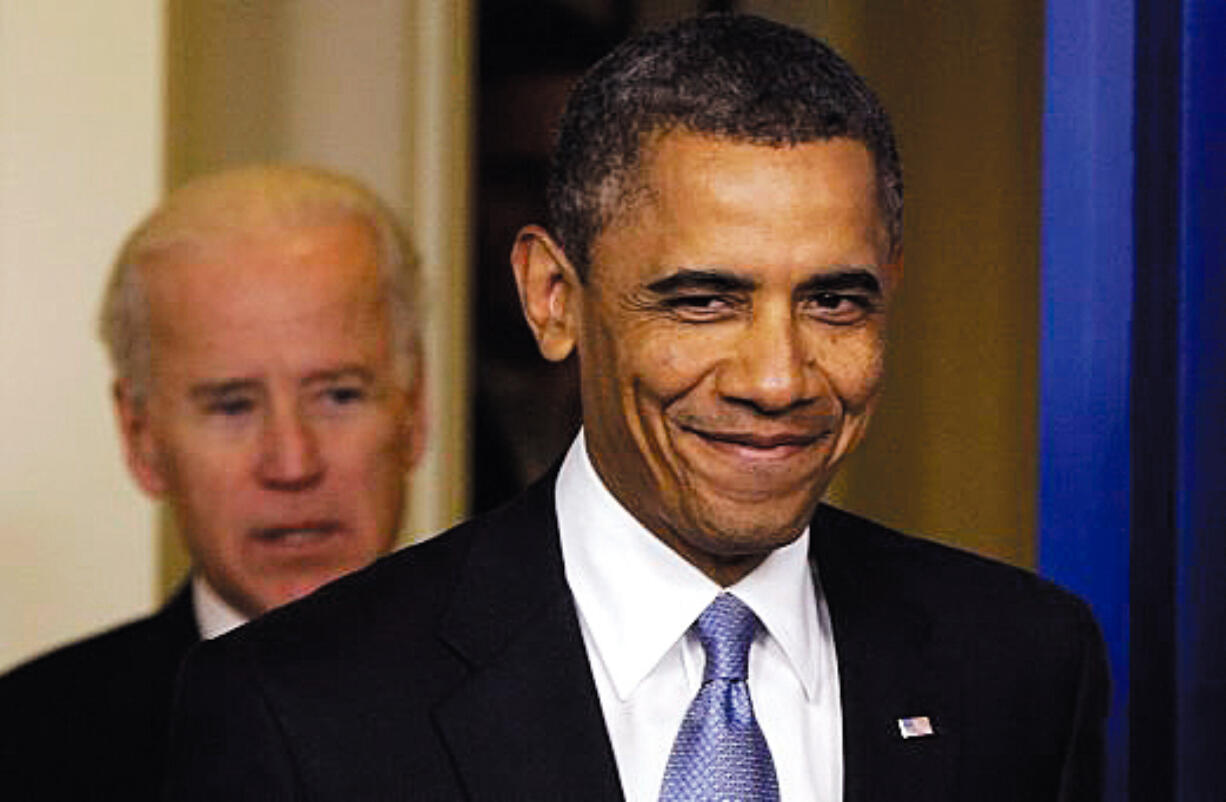 President Barack Obama smiles as he arrives with Vice President Joe Biden to make a statement regarding the passage of the fiscal cliff bill in the Brady Press Briefing Room at the White House in Washington, Tuesday.