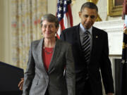 President Barack Obama walks with Interior Secretary-designate REI Chief Executive Officer Sally Jewell following the announcement Wednesday in the State Dining Room of the White House in Washington.