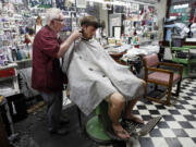 Barber Russell Hiatt, known locally as Floyd, cuts Ethan Boles' hair at Floyd's City Barber Shop in Mount Airy, N.C.