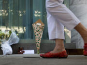 A woman walks past a small memorial Sunday for Canadian actor Cory Monteith outside the Fairmont Pacific Rim Hotel where he died on Saturday in Vancouver, B.C.