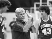 In this Oct. 13, 1977, file photo, Washington coach Marv Harshman shows Scott Hartman, left, how to hold the ball when shooting as Kim Stewart, right, looks on, during a practice session in Seattle. Harshman, who spent 40 years coaching in the state of Washington, died Friday, April 12, 2013.