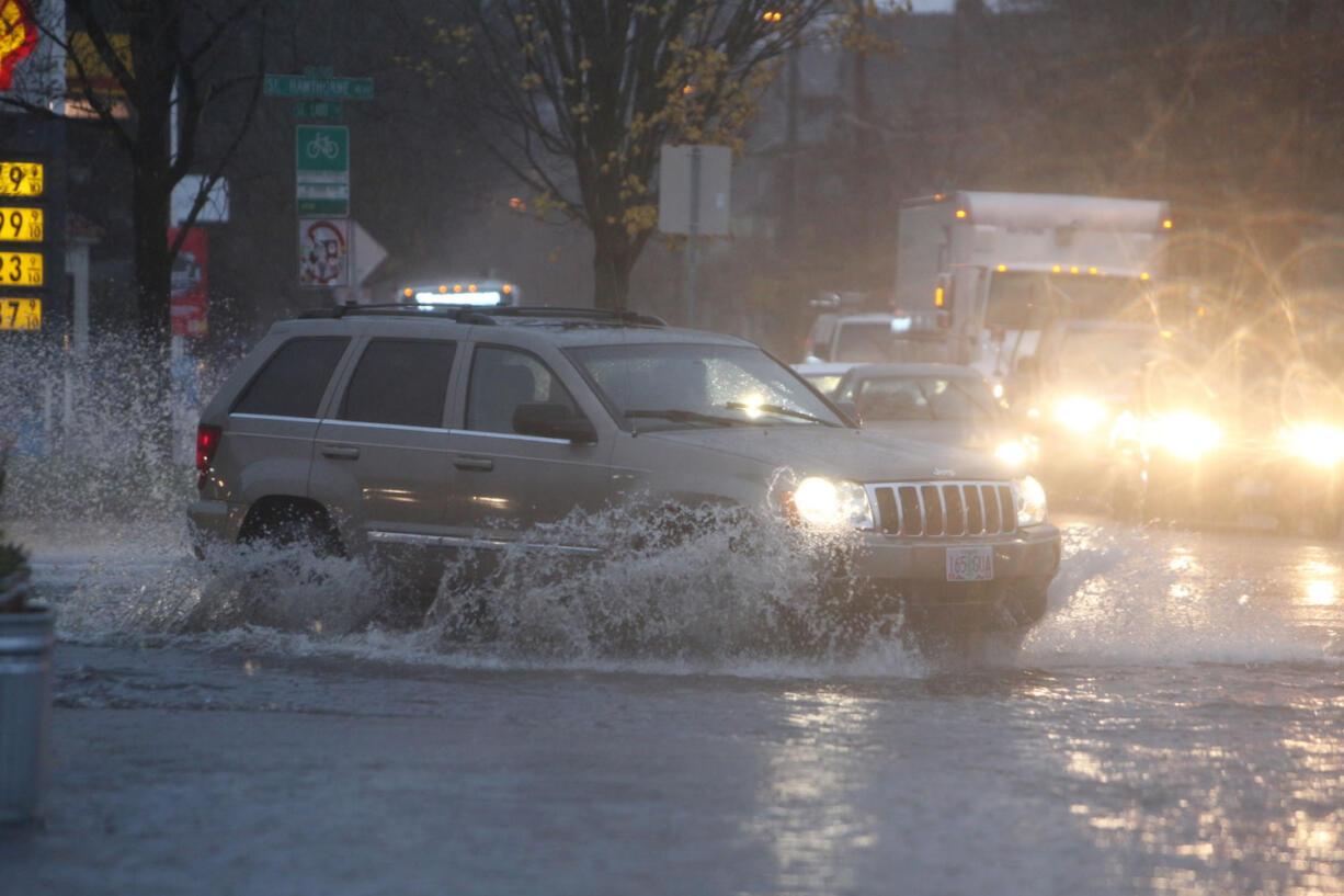 Pouring rain and clogged storm drains caused flooding in the streets near the  corner of SE 12th and Hawthorne on Monday in Portland, Ore.