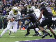 Oregon quarterback Marcus Mariota, left, runs the ball on a keeper play against Washington in the first half of an NCAA college football game, Saturday, Oct. 12, 2013, in Seattle. Mariota was stopped short of the goal line, but Oregon scored a touchdown on the next play. (AP Photo/Ted S.