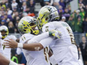 Oregon quarterback Marcus Mariota, right, celebrates with wide receiver Bralon Addison after Mariota scored a touchdown against Washington in the second half of an NCAA college football game, Saturday, Oct. 12, 2013, in Seattle. Oregon won 45-24. (AP Photo/Ted S.