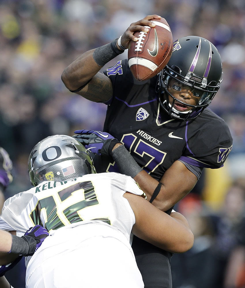 Oregon's Wade Keliikipi (92) sacks Washington quarterback Keith Price in the second half of an NCAA college football game, Saturday, Oct. 12, 2013, in Seattle. Oregon won 45-24.