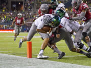 Oregon quarterback Marcus Mariota sees daylight and squeezes into the end zone with his foot barely in, scoring on a 13-yard run in a 2012 game against Washington State in Seattle.