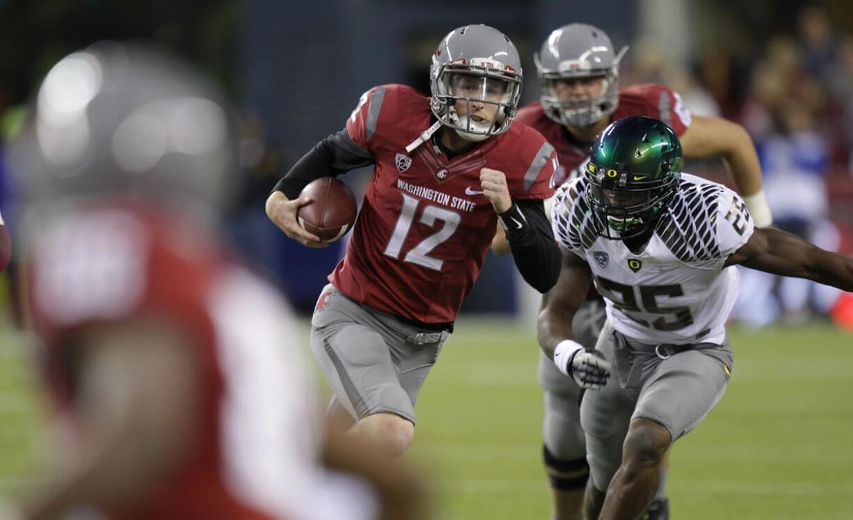 Washington State quarterback Connor Halliday (12) scrambles as Oregon's Boseko Lokombo (25) pursues in the second half Saturday.