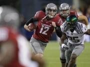 Washington State quarterback Connor Halliday (12) scrambles as Oregon's Boseko Lokombo (25) pursues in the second half Saturday.