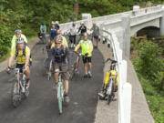 Bicyclists ride on the new McCord Creek Bridge, part of the Historic Columbia River Highway State Trail, near Cascade Locks, Ore. Cyclists will soon have a new recreation option after the missing link in the Historic Columbia River Highway State Trail opens. The section will be fully useable after Oct.