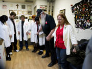 Paul Kitagaki Jr/Sacramento Bee
Bryan and Lanette Davies, right, join hands to lead a prayer each day at 6 p.m. for their staff and patients at the Canna Care marijuana dispensary in Sacramento, Calif.