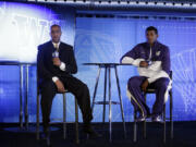 Washington head coach Lorenzo Romar, left, answers questions alongside C.J. Wilcox during the Pac-12 NCAA college basketball media day on Thursday, Oct. 17, 2013, in San Francisco.