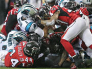 Carolina Panthers quarterback Cam Newton is swarmed by Atlanta Falcons defenders during the second half of an NFL football game on Sunday, Dec. 27, 2015, in Atlanta.