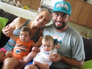 Laura Radocaj shares household and child-rearing duties with her husband, Marco They are holding their twins, Rudy, left, and Ryan in Vero Beach, Fla.