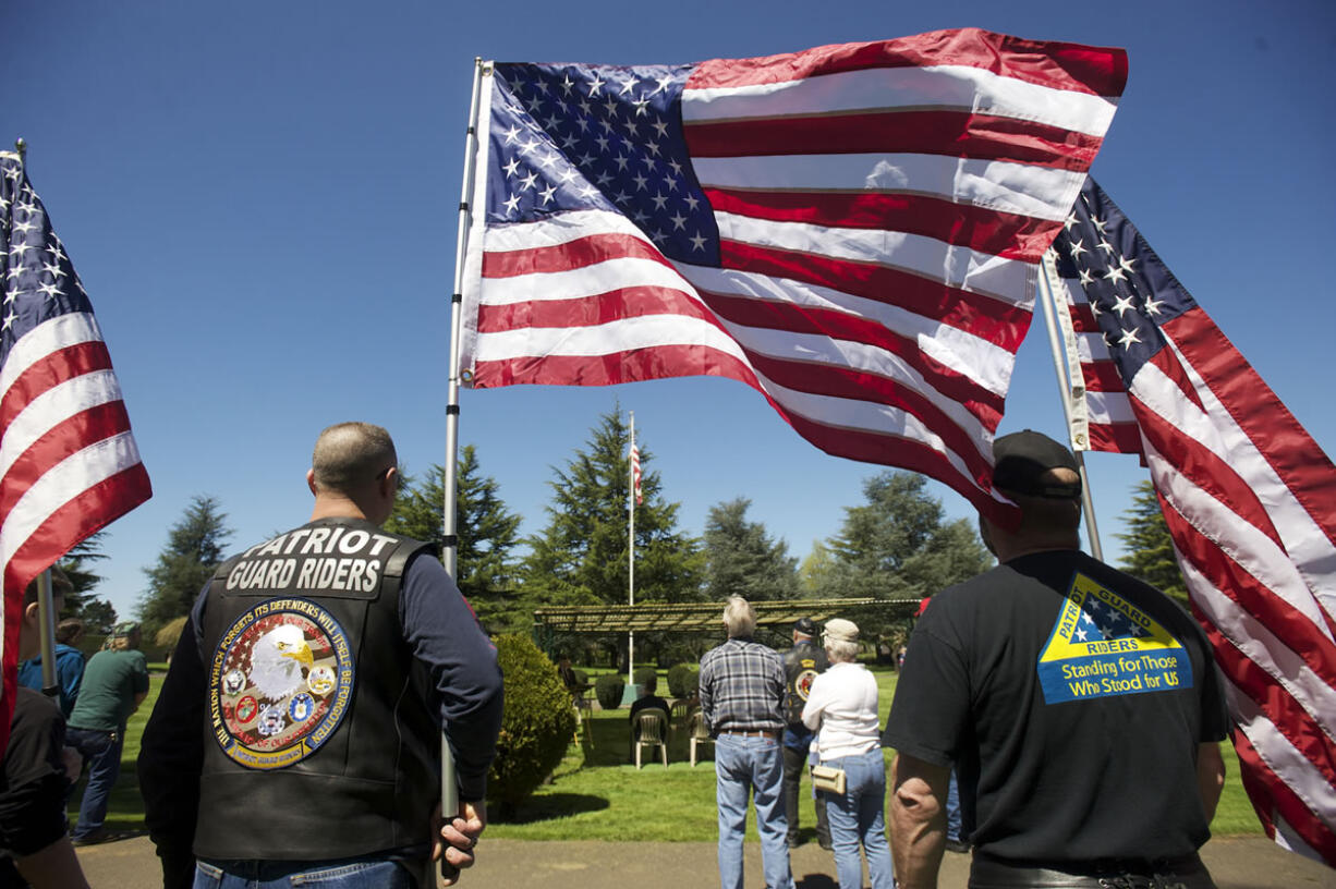 Patriot Guard Riders hold flags during a memorial service for veterans who did not receive a full military funeral in 2013 at Evergreen Memorial Gardens.