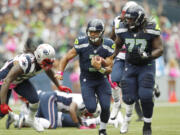 Seattle Seahawks quarterback Russell Wilson carries the ball in the first half of Seattle's 24-23 win over New England on Sunday in Seattle.